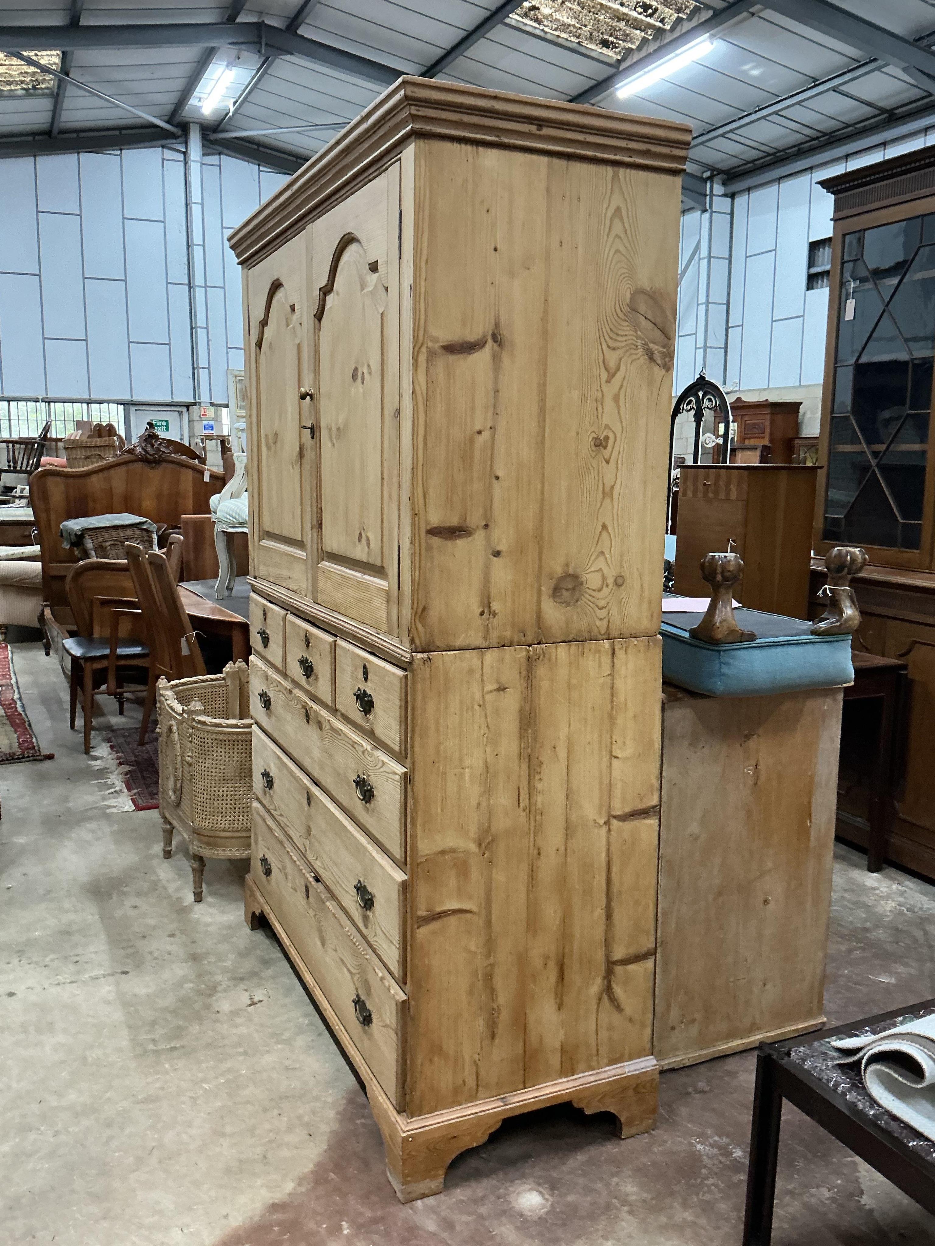 An early 19th century pine two part press cupboard, width 125cm, depth 54cm, height 191cm